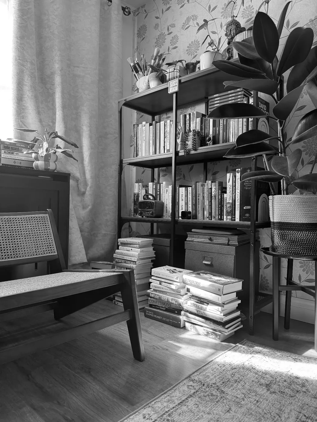 A reading chair beside bookshelves in natural window light